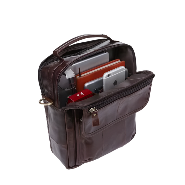 Zaino in pelle marrone con scomparti aperti, contenente laptop, tablet e smartphone. Ideale per lavoro e viaggio. Accessorio elegante e funzionale.