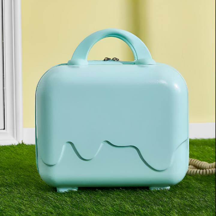 Valigia rigida verde menta su erba sintetica, design moderno e compatto, ideale per viaggi brevi. Sfondo giallo chiaro, manico ergonomico.