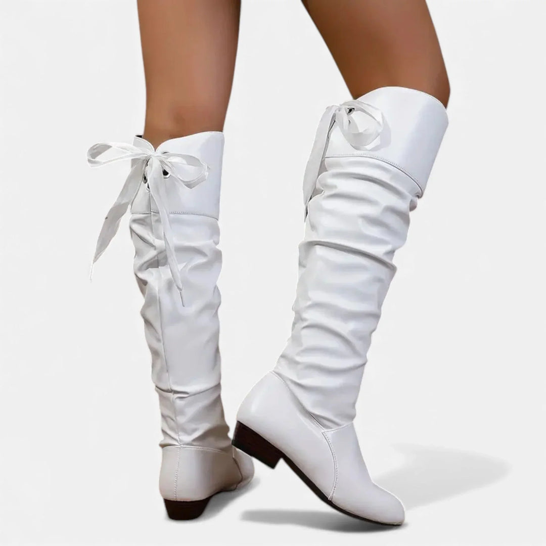 Bottes mi-hautes blanches pour femme, en matériau doux, avec nœud décoratif et talon bas pour un confort optimal.