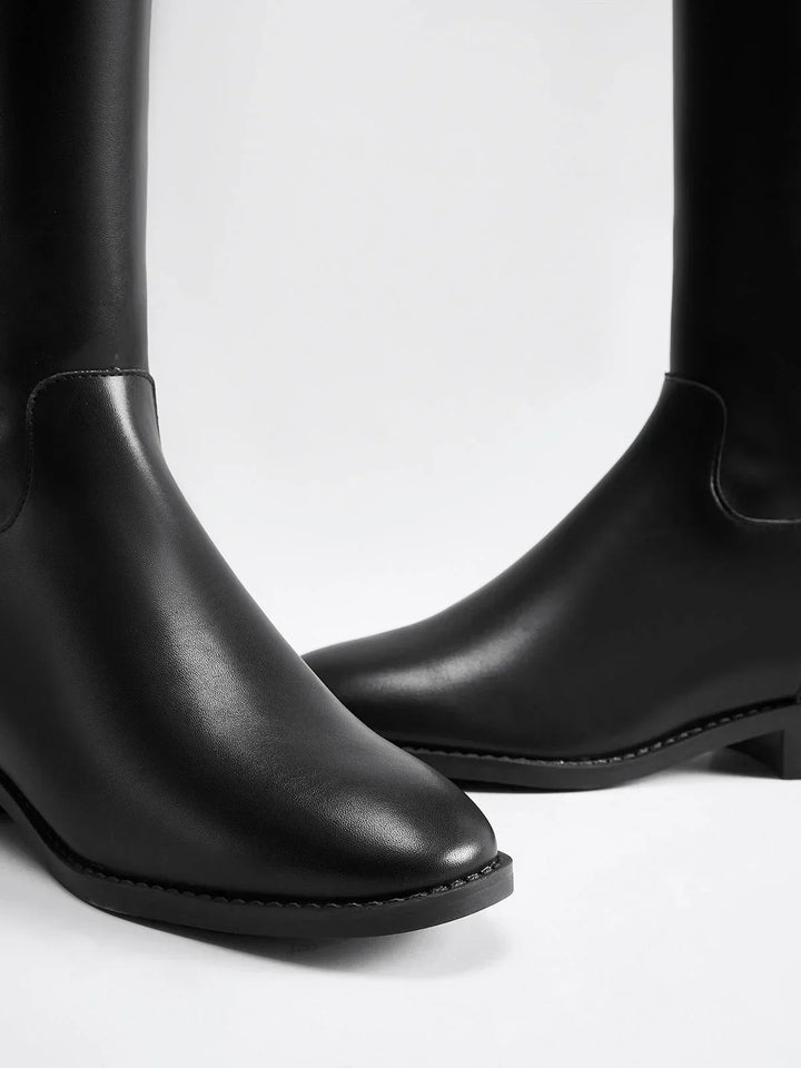 Bottes noires équestres en cuir avec boucle décorative sur le côté. Construction élégante et robuste.
