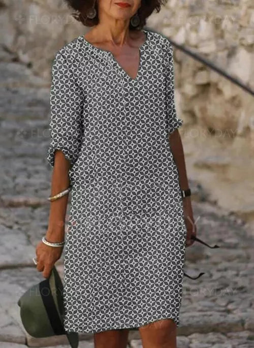 Abito estivo donna, motivo geometrico bianco e nero, maniche a tre quarti, scollo a V, stile casual elegante, perfetto per passeggiate estive.
