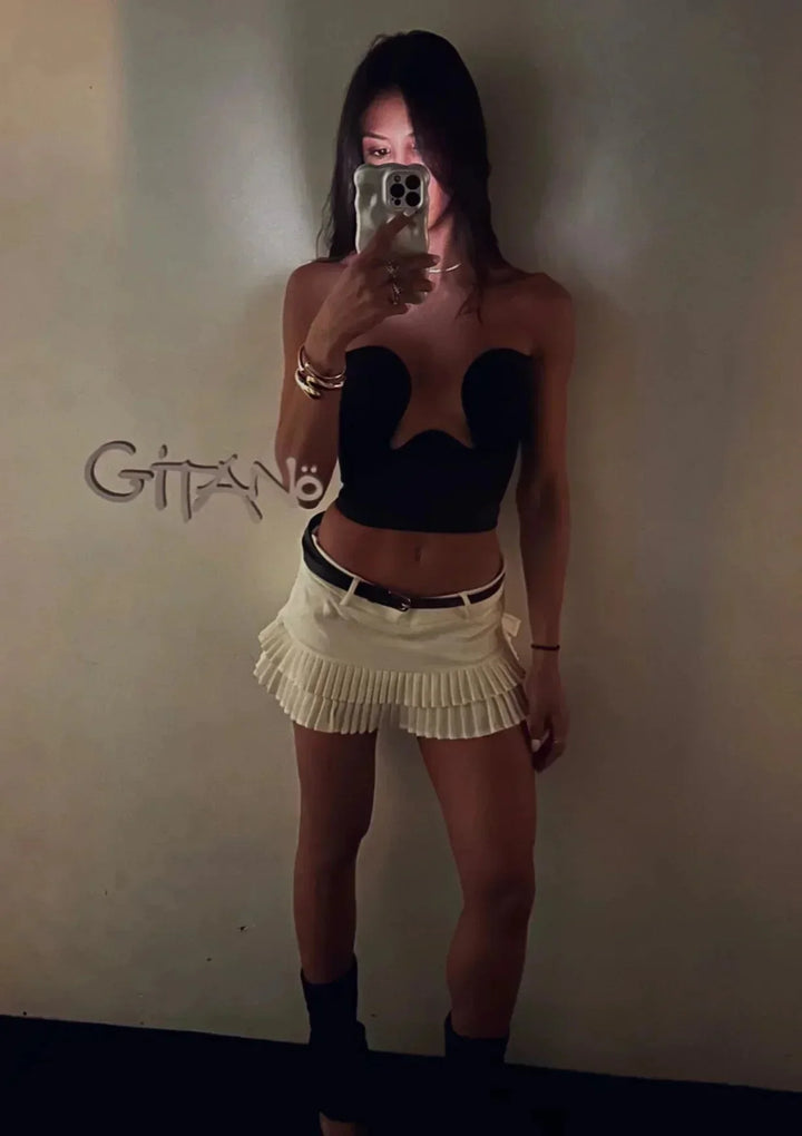 Bustier femme sans bretelles en tissu extensible, avec une découpe ondulée élégante pour un look moderne et distinctif.