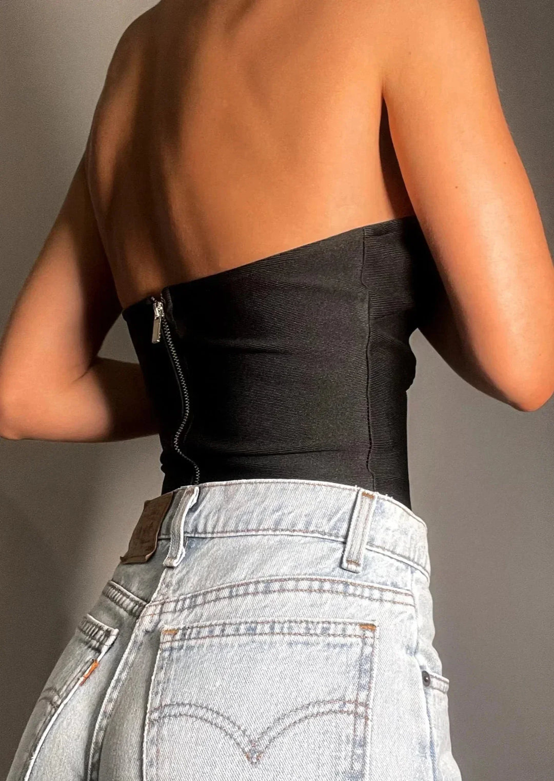 Bustier femme sans bretelles en tissu élastique, avec découpe ondulée élégante et ajustement confortable.