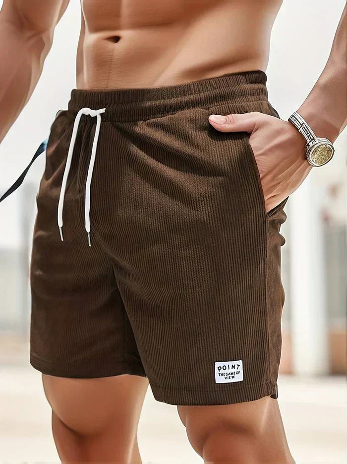 Shorts da uomo marroni in velluto a coste, con tasche laterali e laccio bianco in vita. Ideali per moda estiva e casual.