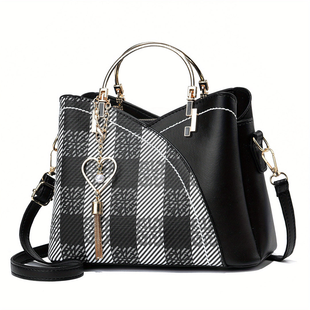 Borsa a mano elegante in pelle nera con motivo a quadri bianchi e neri, decorata con ciondolo a cuore, manici dorati e tracolla regolabile.