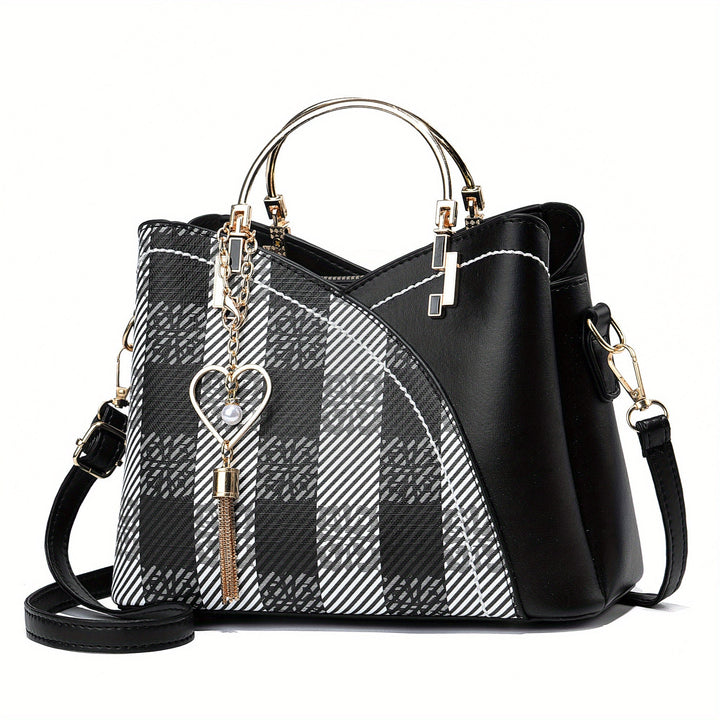 Borsa a mano elegante in pelle nera con motivo a quadri bianchi e neri, decorata con ciondolo a cuore, manici dorati e tracolla regolabile.