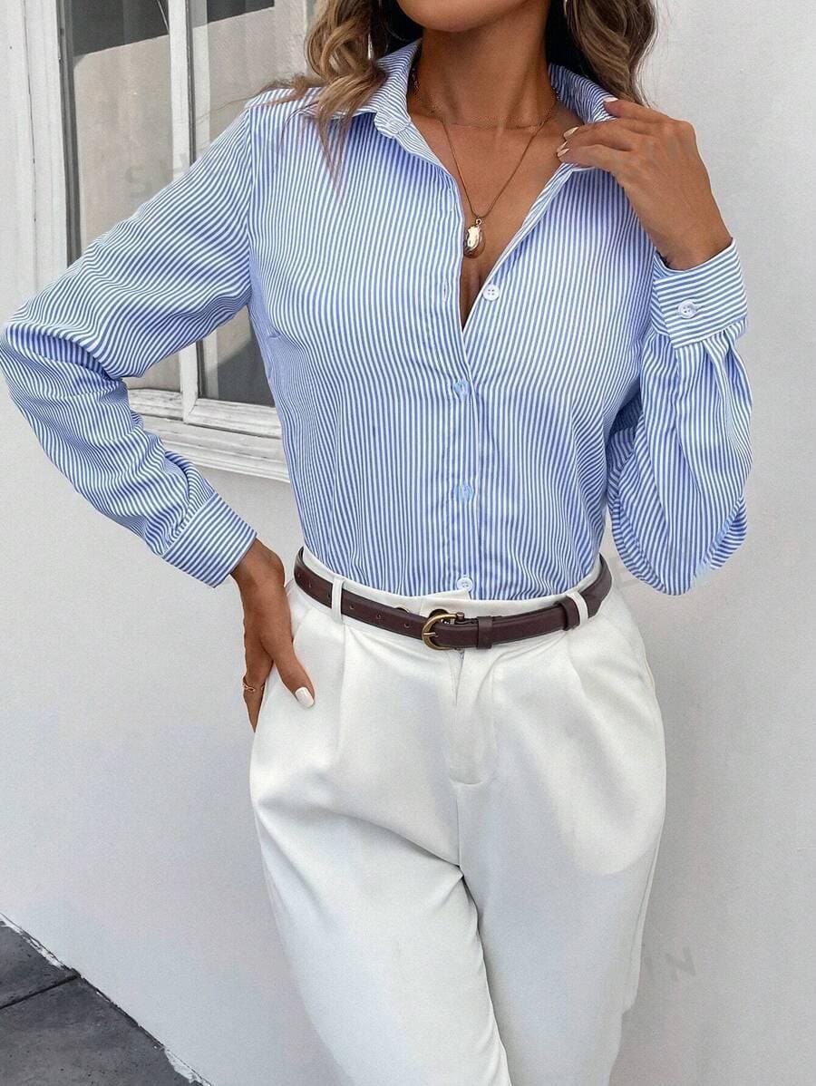 Camicia a righe blu e bianche da donna, abbinata a pantaloni bianchi eleganti. Look casual chic, perfetto per l&
