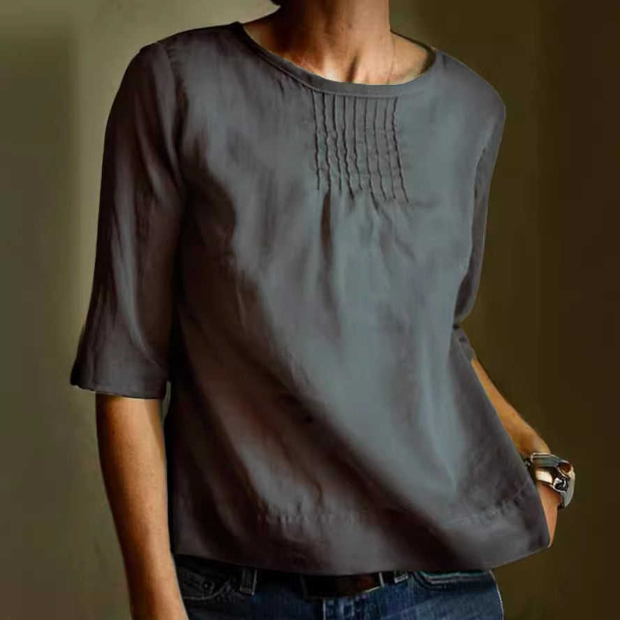 Blusa grigia da donna con maniche a tre quarti, scollo rotondo e dettagli a pieghe sul petto. Elegante e casual, ideale per ogni occasione.