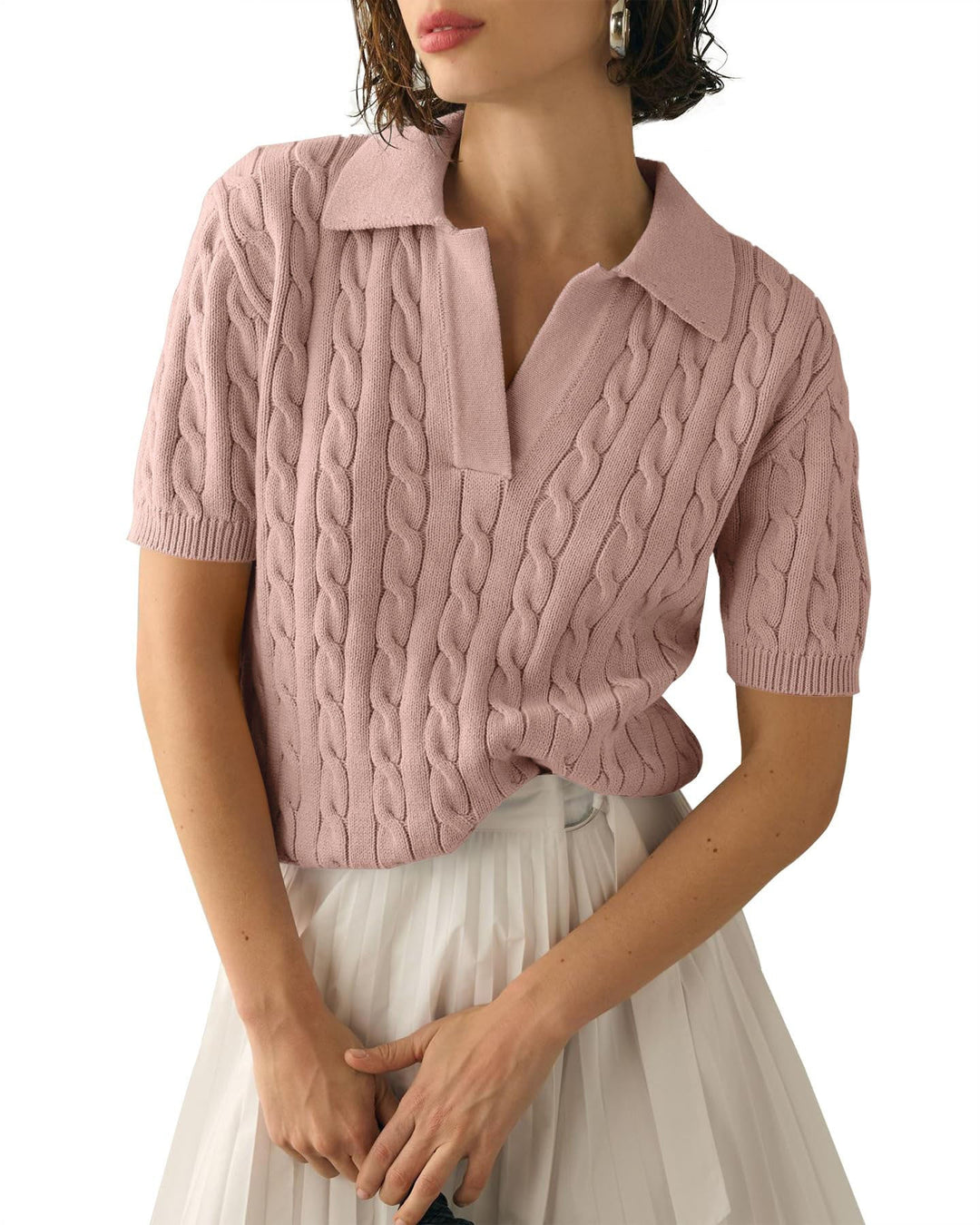 Maglione rosa a trecce con colletto, maniche corte, indossato da donna. Elegante e casual, perfetto per moda femminile primavera-estate.