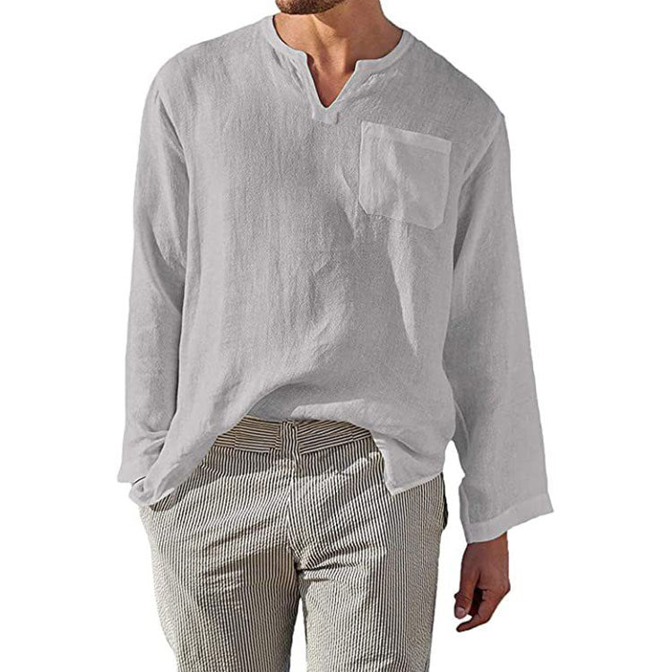 Camicia uomo bianca in lino con scollo a V e taschino, maniche lunghe, abbinata a pantaloni a righe. Stile casual estivo, moda maschile.