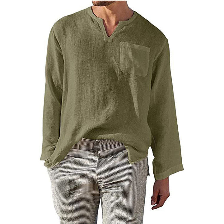 Camicia uomo verde oliva in lino, maniche lunghe, scollo a V, taschino frontale, abbinata a pantaloni a righe. Stile casual elegante.