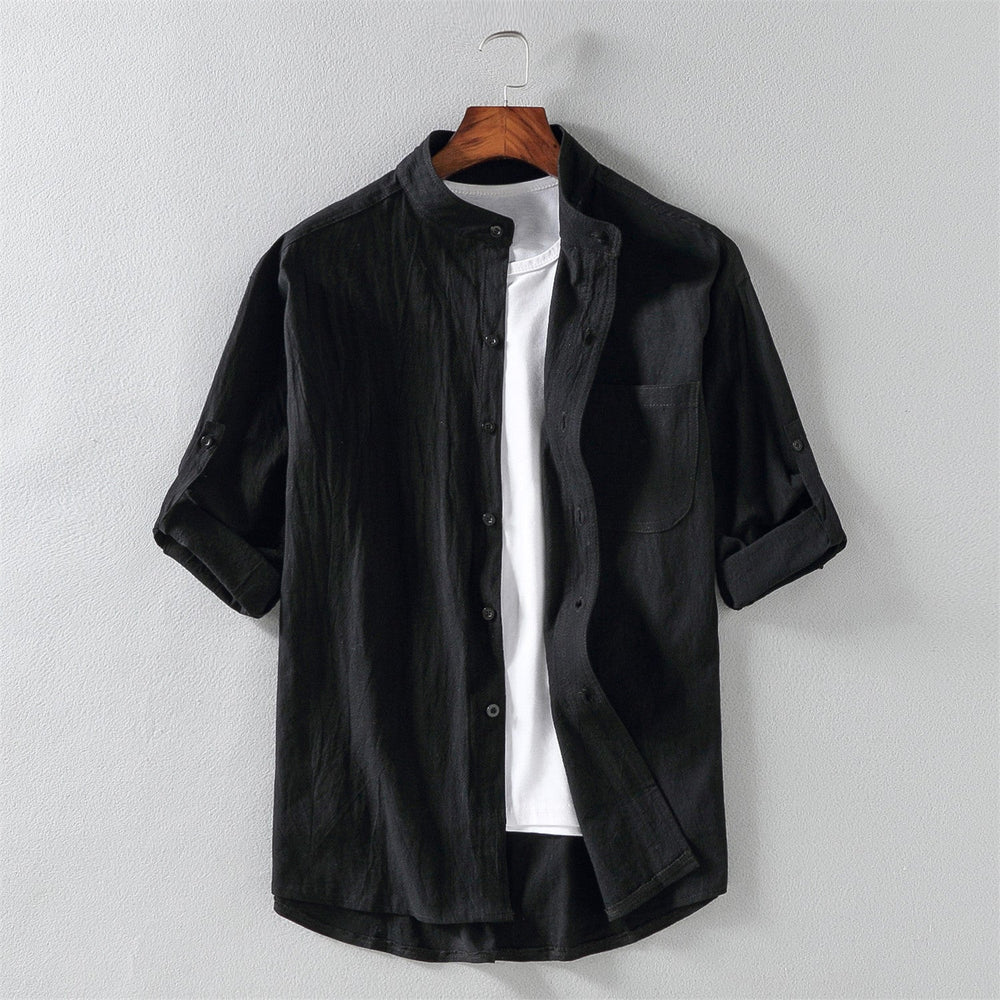 Camicia nera da uomo in cotone, maniche lunghe arrotolate, colletto alla coreana, abbinata a t-shirt bianca. Elegante e casual.