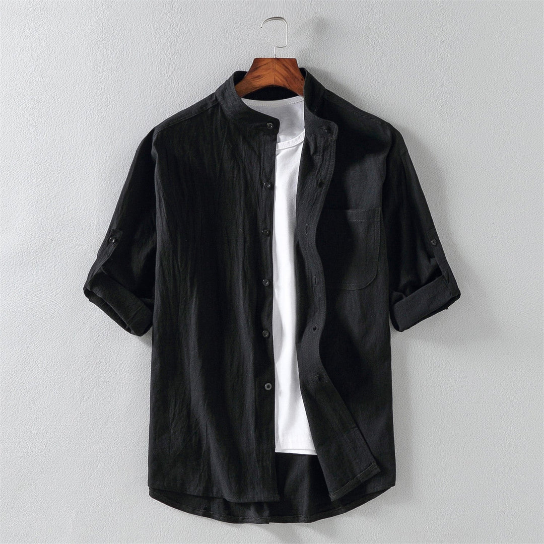 Camicia nera da uomo in cotone, maniche lunghe arrotolate, colletto alla coreana, abbinata a t-shirt bianca. Elegante e casual.