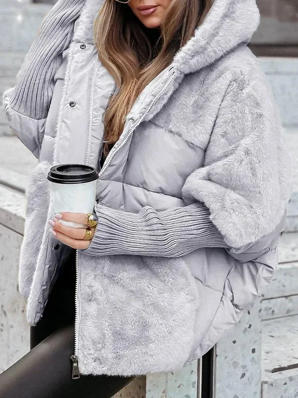 Cape d'hiver matelassée noire avec capuche et col en fausse fourrure, conçue pour les jours froids.