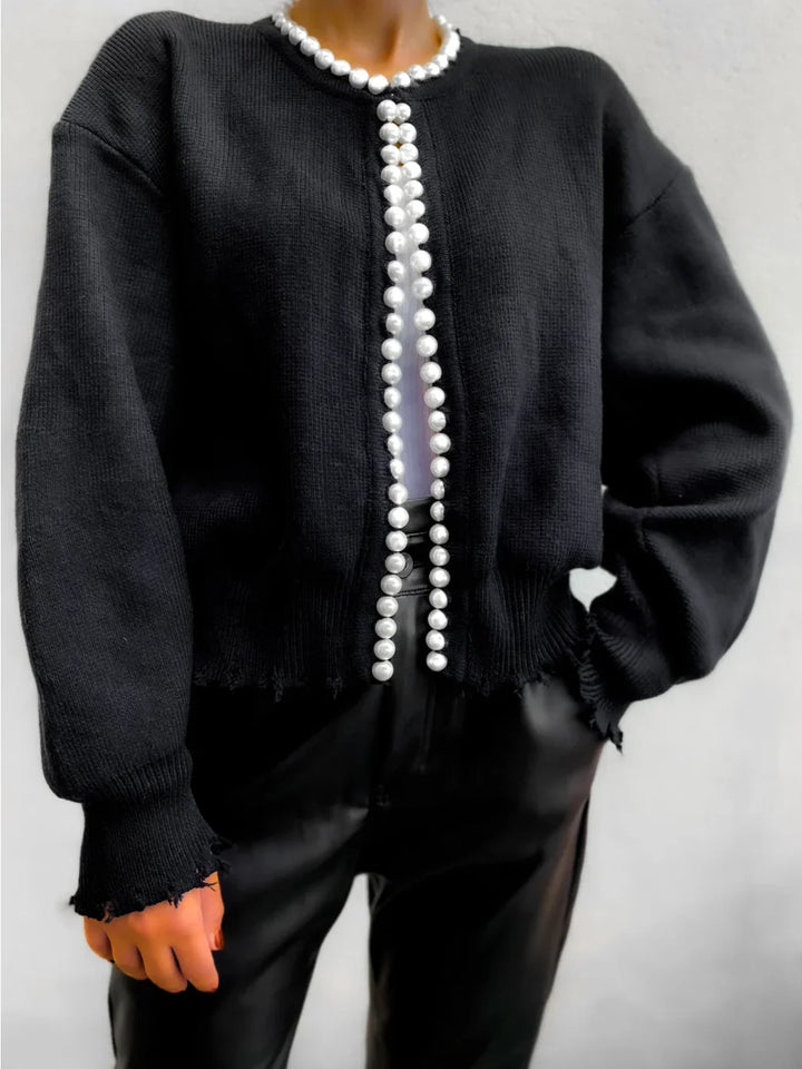 Cardigan femme noir en matière douce, avec détails en perles et coupe classique pour des looks variés.