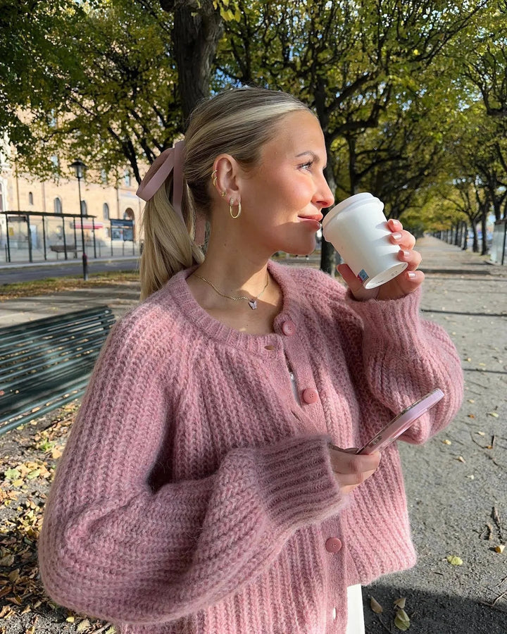 Cardigan femme en maille rose avec boutons sur le devant et design classique.
