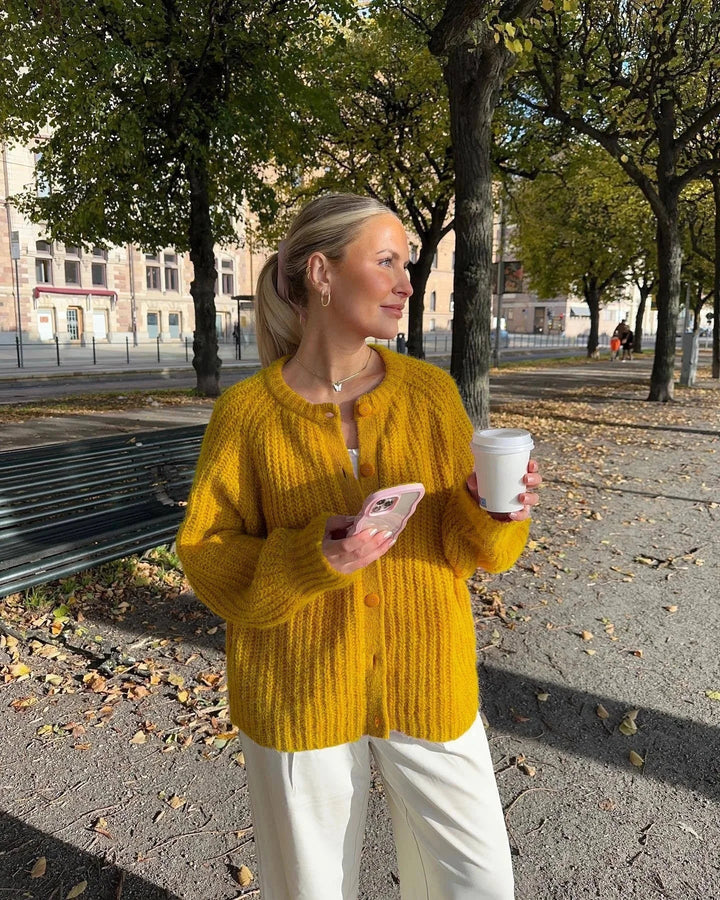 Cardigan femme en maille rose avec boutons sur le devant, conçu pour les journées fraîches et les tenues variées.