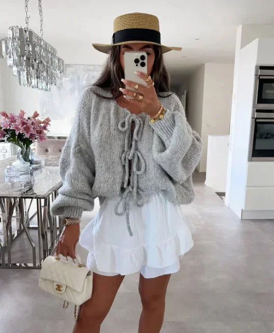 Cardigan femme rose avec manches amples et design noué, parfait pour des tenues décontractées.