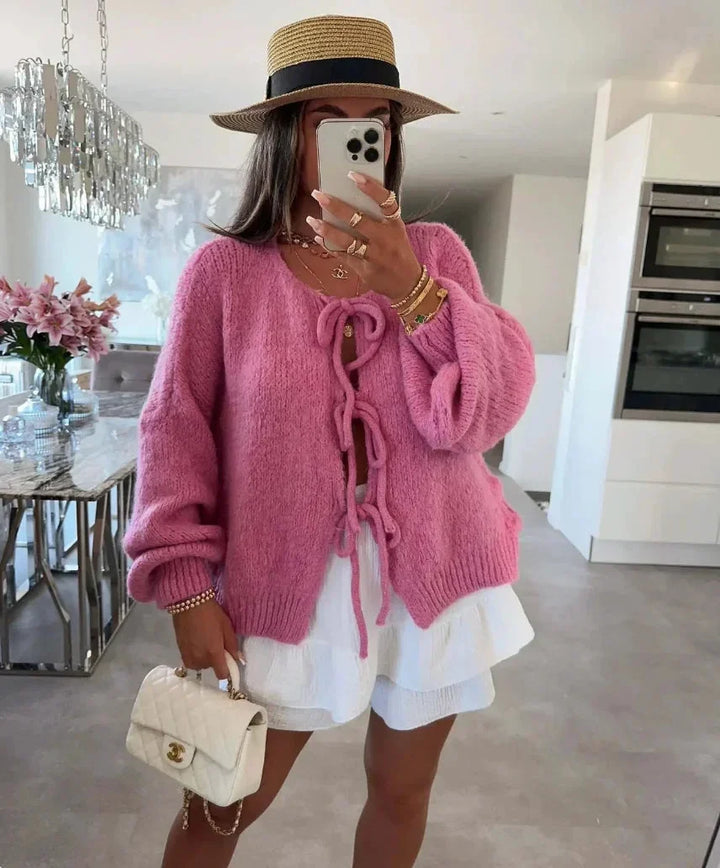 Cardigan femme en tricot rose, coupe ample avec manches nouées pour un style décontracté.