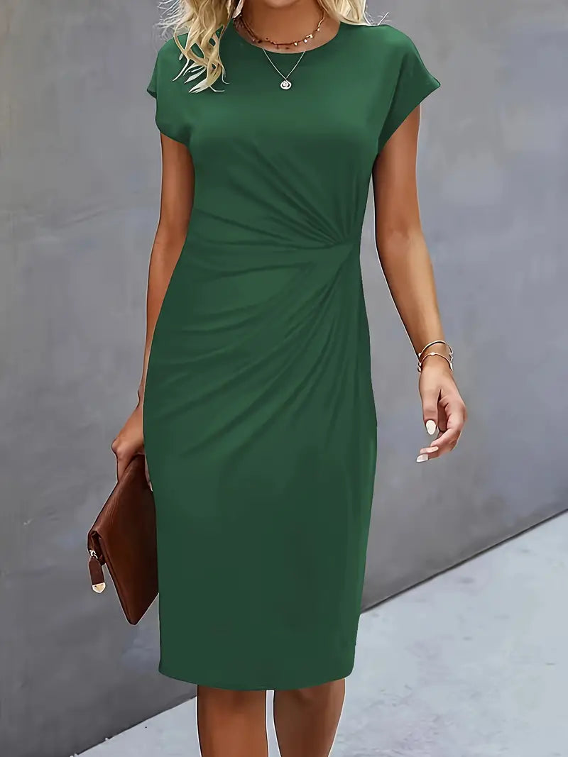 Abito verde elegante da donna, maniche corte, lunghezza al ginocchio, adatto per occasioni formali. Accessori: borsa marrone, gioielli discreti.