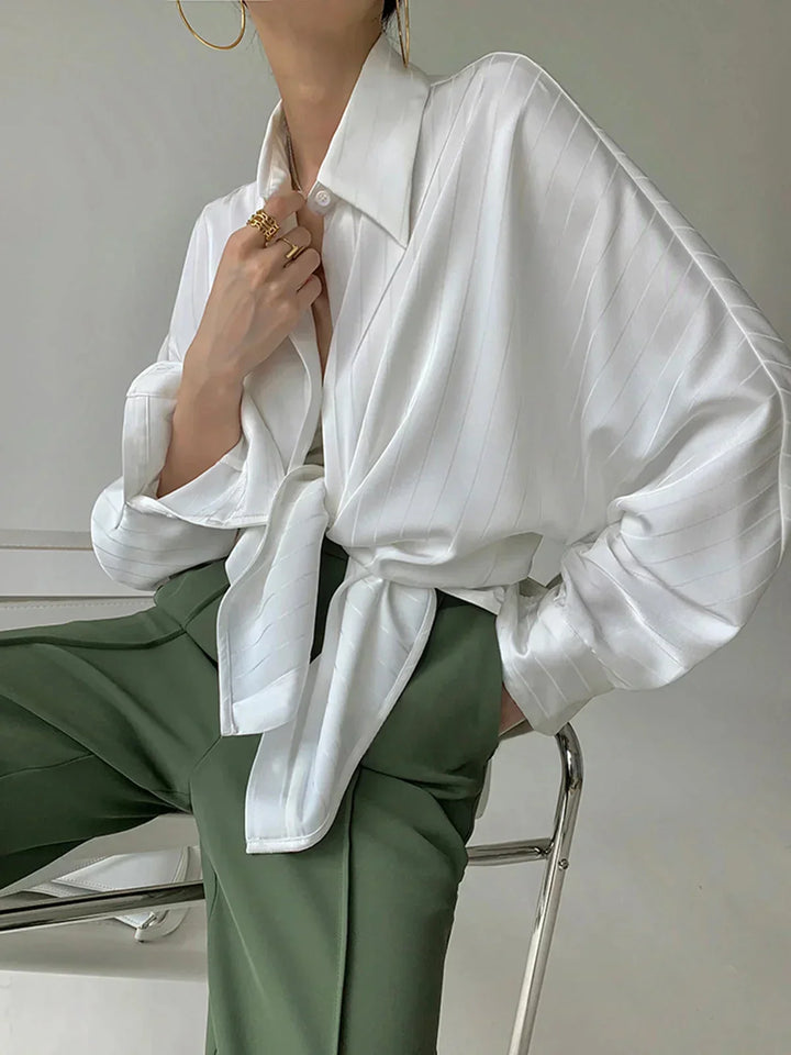 Chemise blanche pour femme en viscose, boutons dorés, col classique et accents raffinés pour un style sophistiqué.
