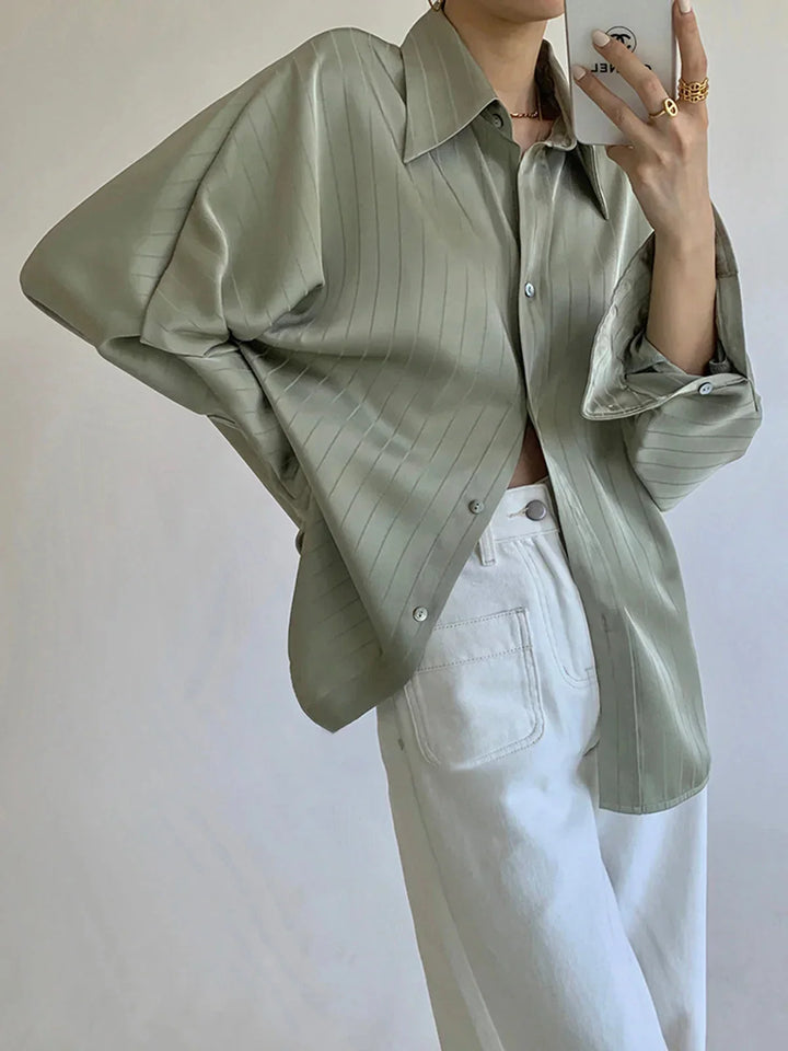 Chemise femme verte avec boutons dorés, fabriquée en coton léger, présente des accents raffinés parfaits pour un look chic.