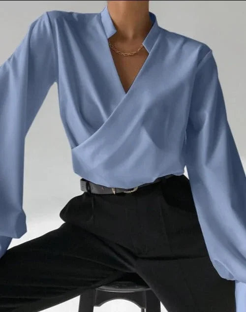 Chemisier femme blanc col en V, manches longues ajustées en coton léger au design classique.