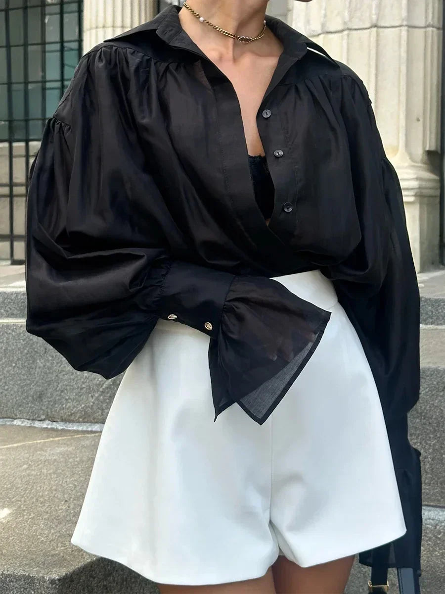 Chemisier femme blanc à col classique, manches évasées, en tissu léger et respirant.