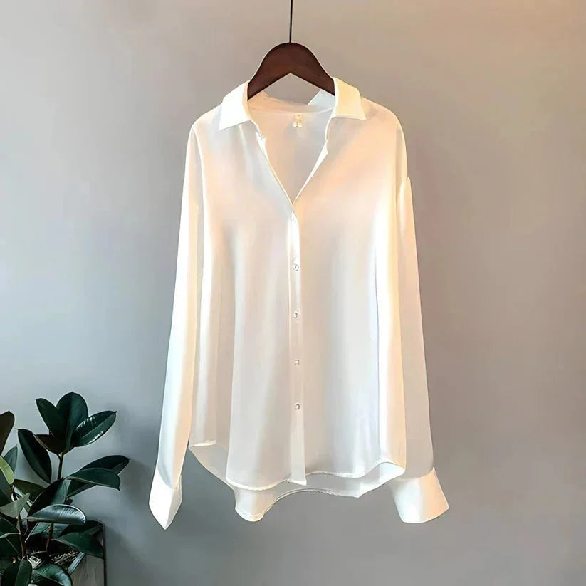 Chemisier beige en satin, manches longues, avec une fermeture à boutons sur toute la longueur.