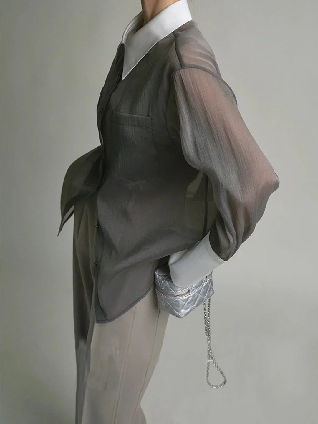 Chemisier transparent en tissu léger à boutons, avec col élégant, parfait pour un look sophistiqué et décontracté.