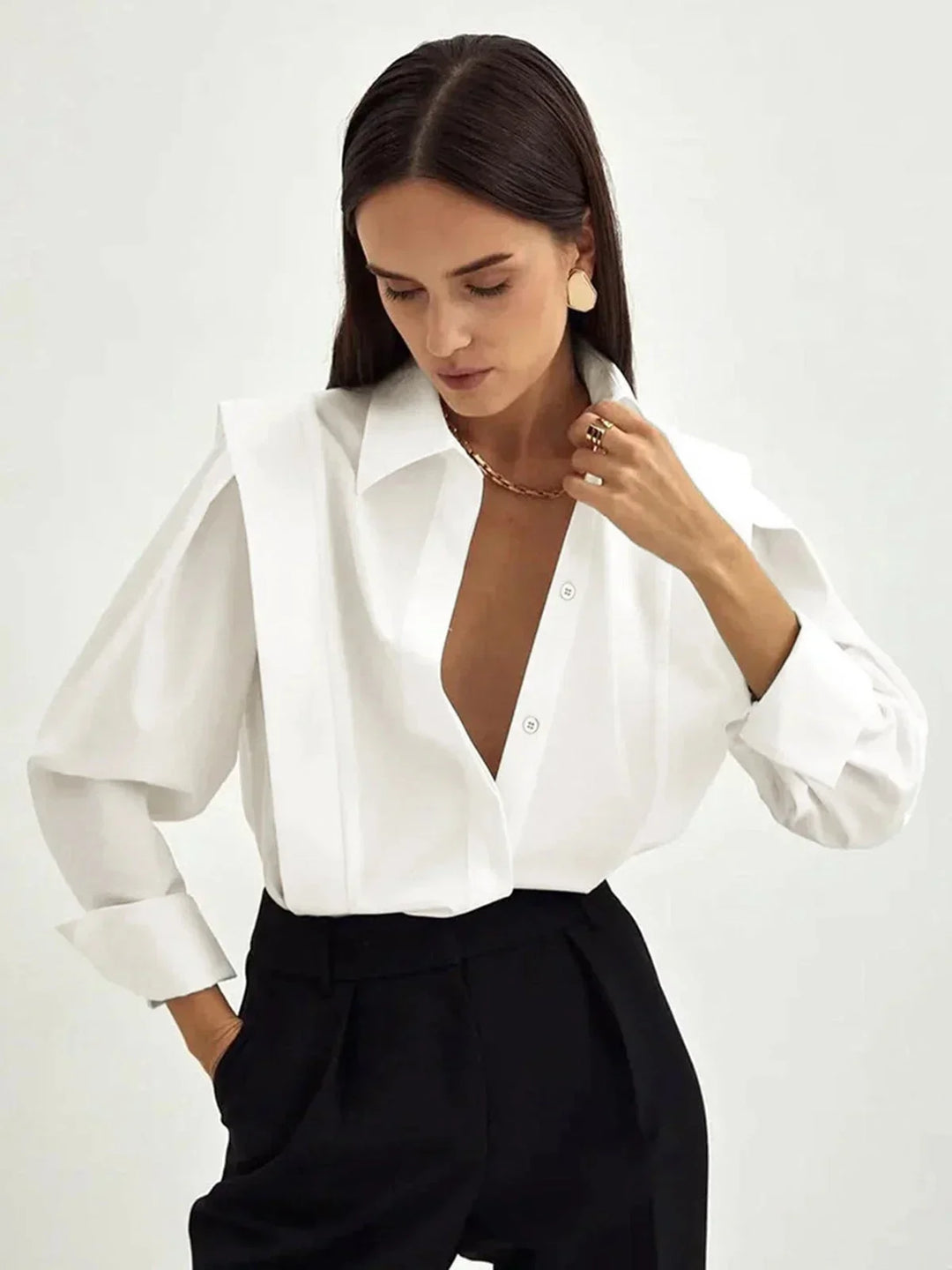 Chemisier oversize en coton, avec des détails boutonnés sur les manches et le col, idéal pour un look décontracté.