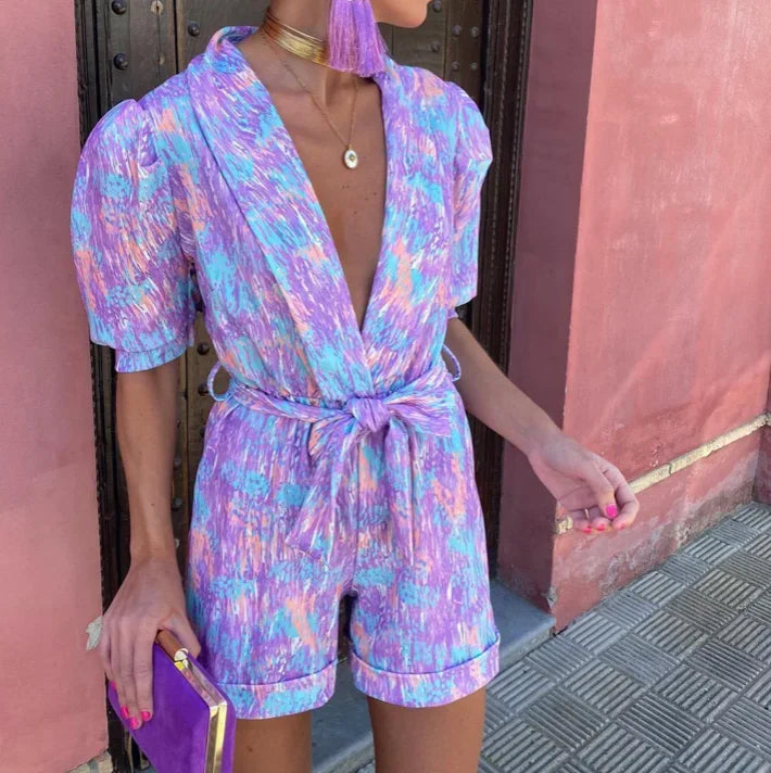 Combinaison courte femme en tissu doux, avec manches bouffantes, ceinture nouée et design élégant.