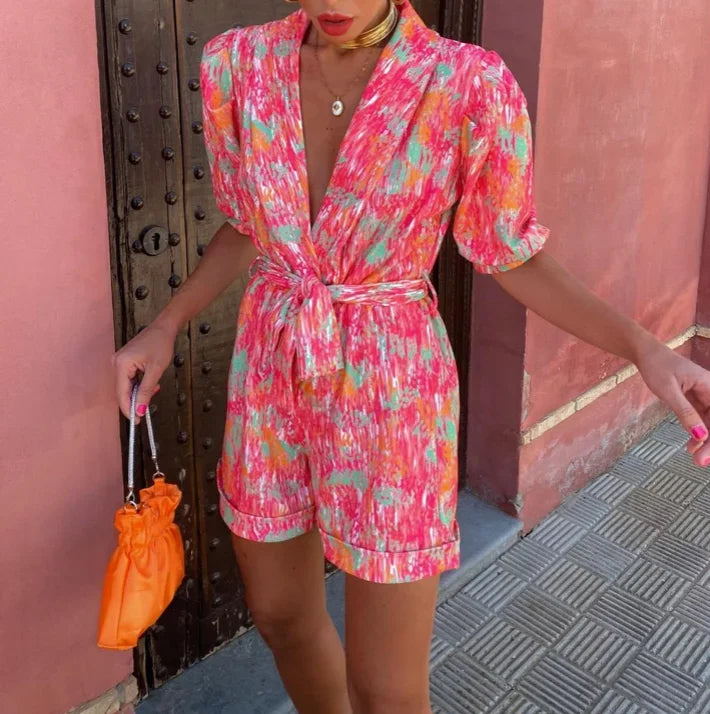 Combinaison courte femme en tissu léger, avec manches bouffantes et ceinture nouée pour un look élégant et confortable.