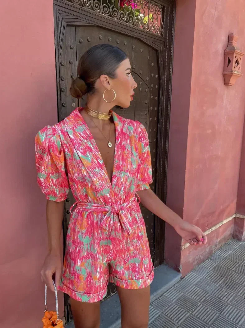 Combinaison courte rose en coton, avec manches bouffantes et ceinture nouée pour un look décontracté et féminin.