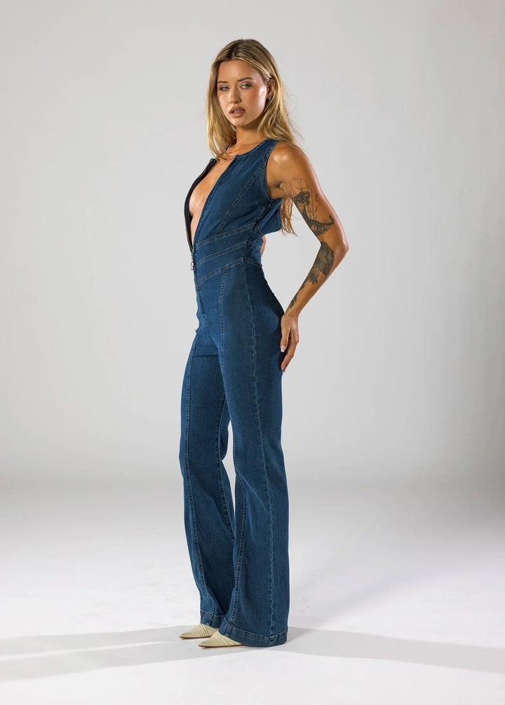 Combinaison en denim bleu marine pour femme, décolleté V profond, coupe décontractée.