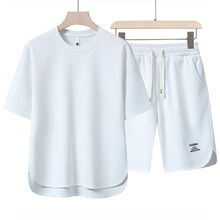 Set abbigliamento sportivo bianco, maglietta e pantaloncini in cotone, design minimalista, ideale per palestra e attività all&
