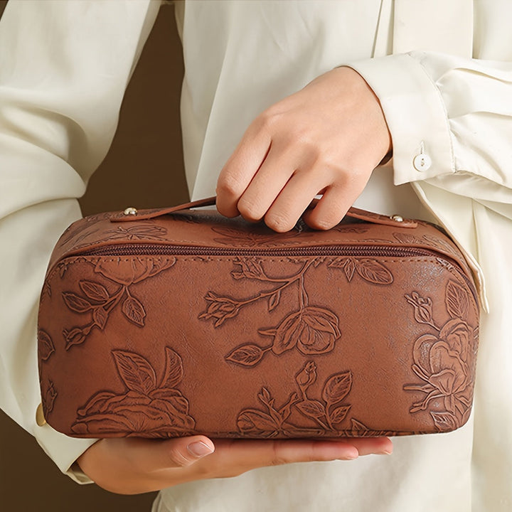 Borsa a mano in pelle marrone con motivo floreale in rilievo, elegante e raffinata, ideale per moda femminile e accessori di lusso.
