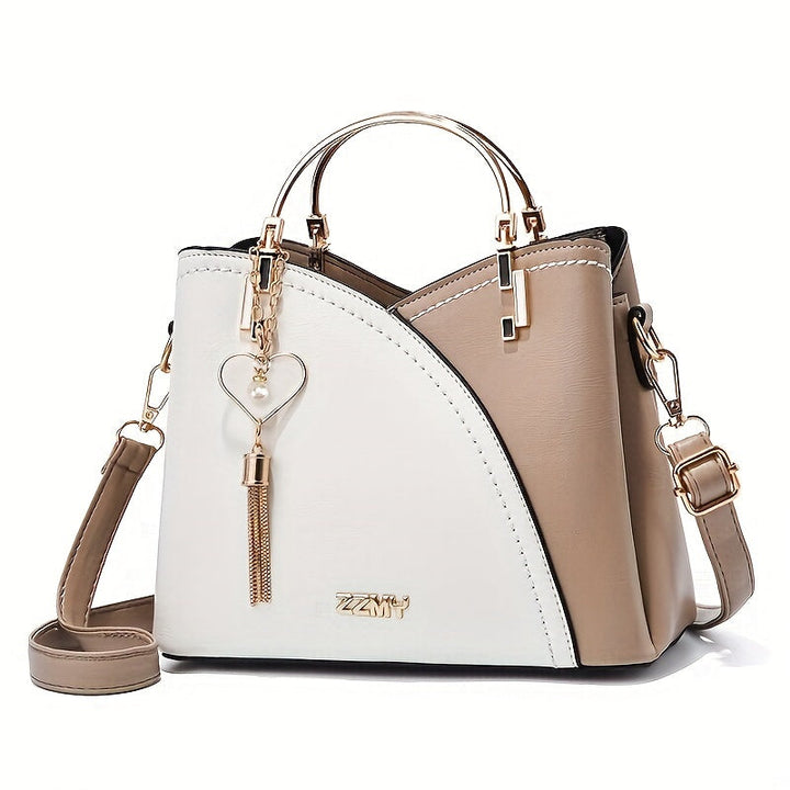 Borsa a tracolla donna in pelle bicolore bianca e beige, design elegante con ciondolo a cuore, manico dorato, ideale per moda e shopping.