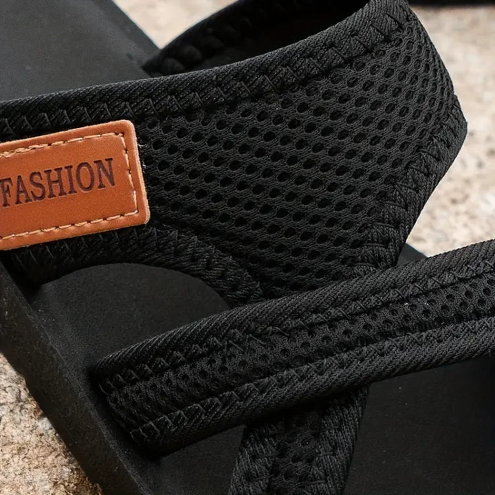 Sandalo nero da uomo in tessuto traspirante con etichetta marrone "FASHION", suola robusta, ideale per l'estate e il tempo libero.