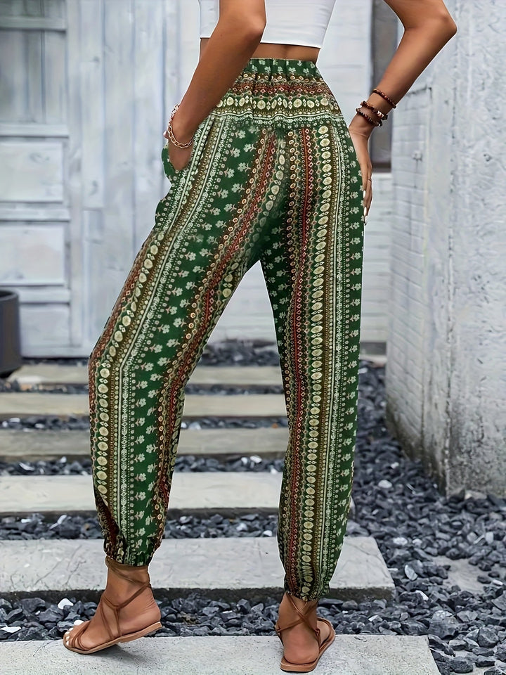 Pantaloni boho verdi a vita alta con stampa floreale, indossati da una donna. Stile casual estivo, perfetti per look rilassati e alla moda.