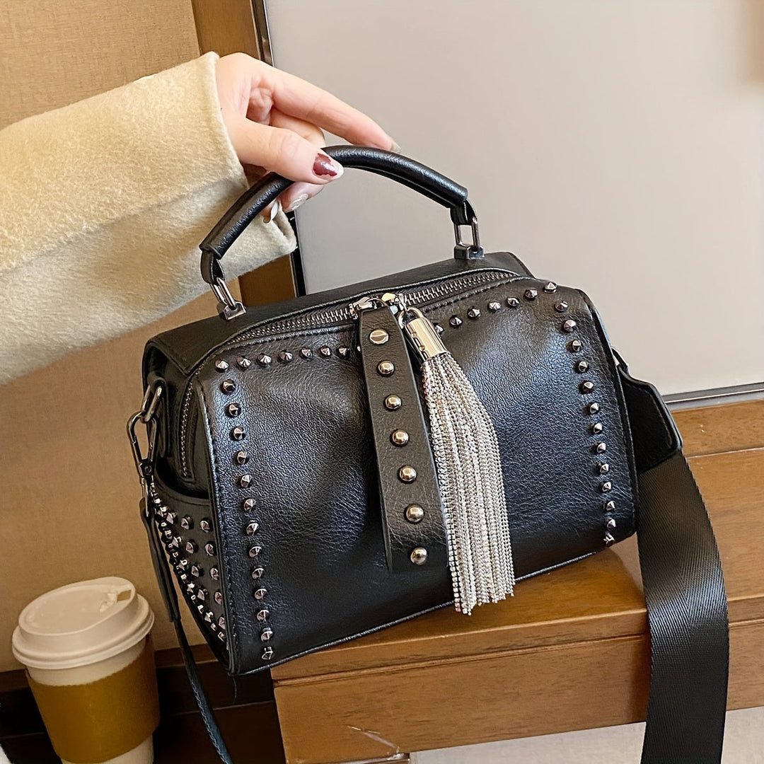 Borsa a mano nera in pelle con borchie e frange metalliche, design elegante, perfetta per moda donna. Accessorio chic e moderno.