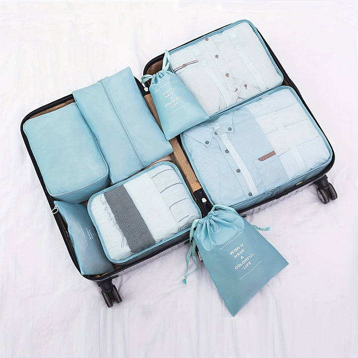 Valigia aperta con organizer da viaggio blu, contenente abbigliamento piegato ordinatamente. Set di borse per valigia, accessori viaggio, organizzazione bagagli.