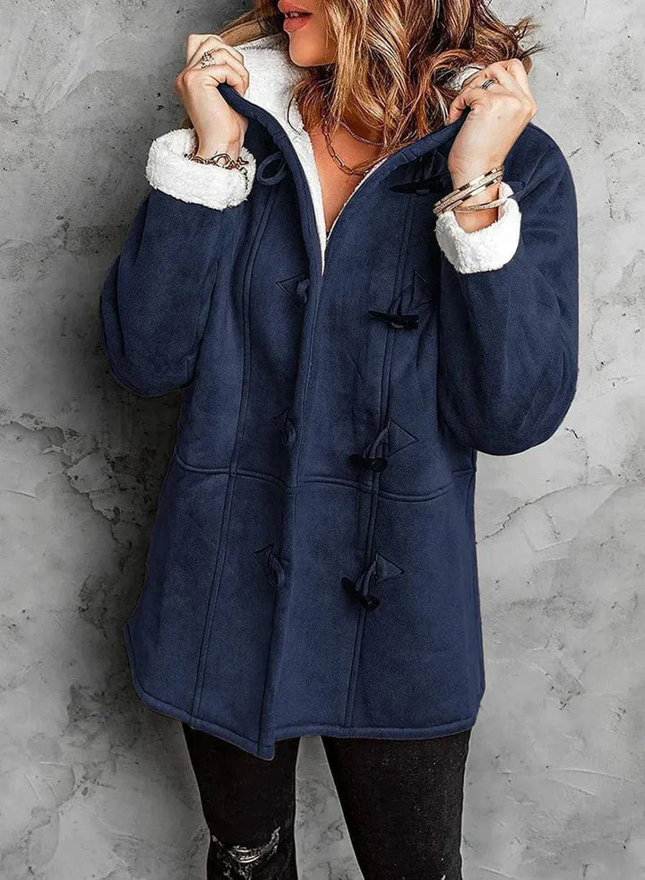 Giacca invernale donna blu scuro con cappuccio, chiusura a bottoni, fodera in pelliccia sintetica bianca, stile casual elegante.