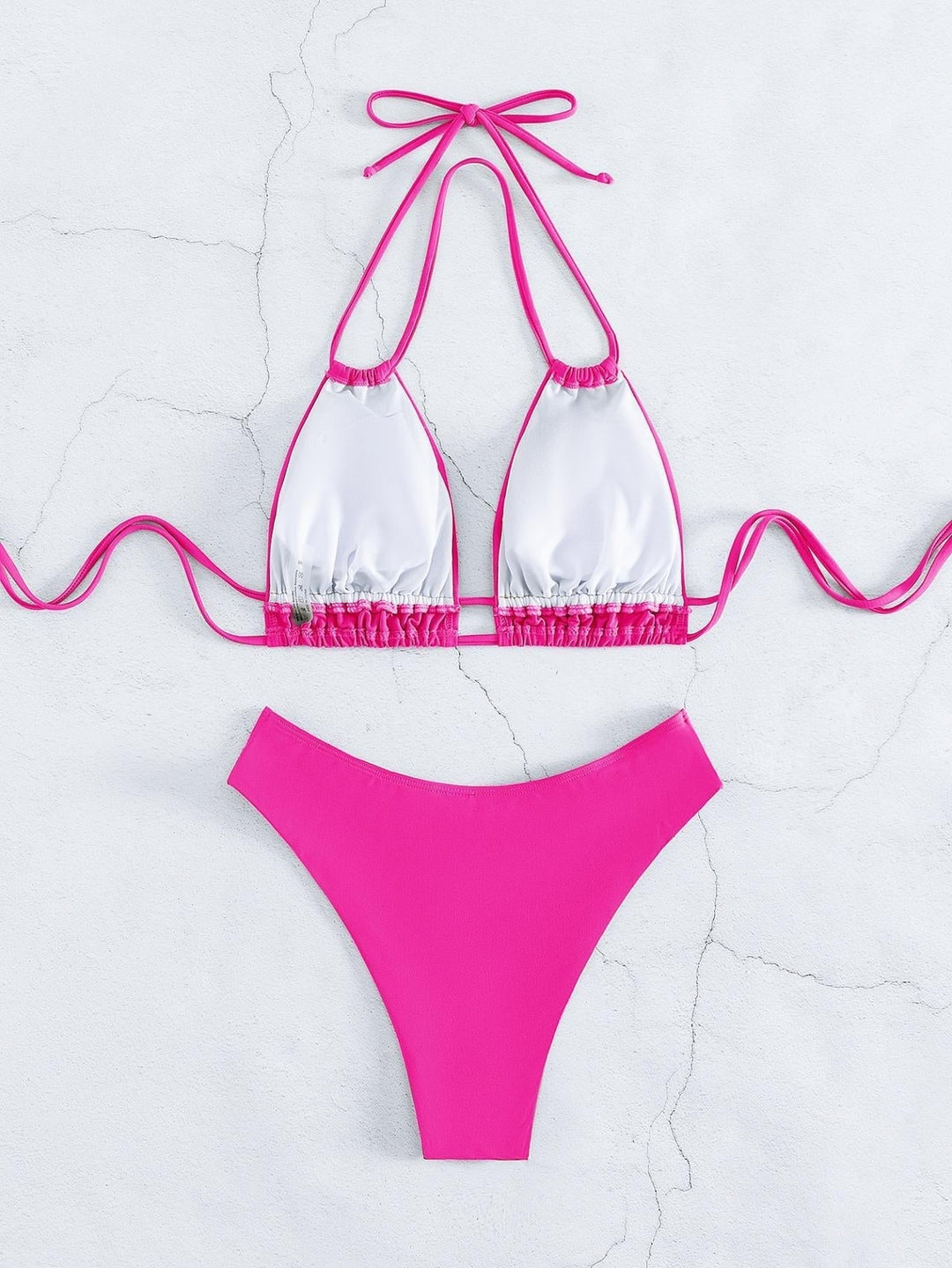 Bikini donna due pezzi, top triangolo bianco e slip fucsia, moda mare estiva, costume da bagno elegante, tendenza spiaggia 2023.