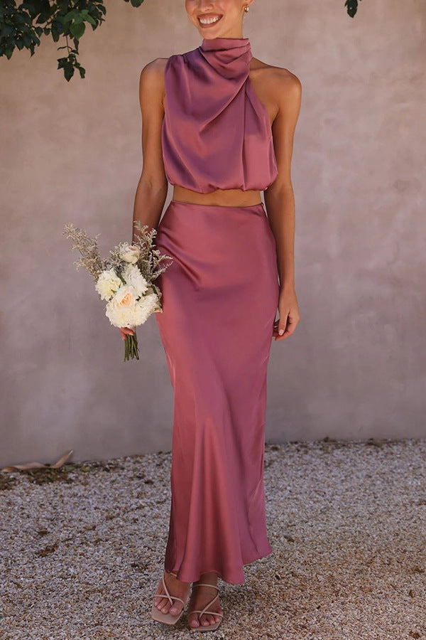 Abito da cerimonia elegante in raso rosa, top senza maniche e gonna lunga, bouquet di fiori bianchi, moda donna, abbigliamento estivo.