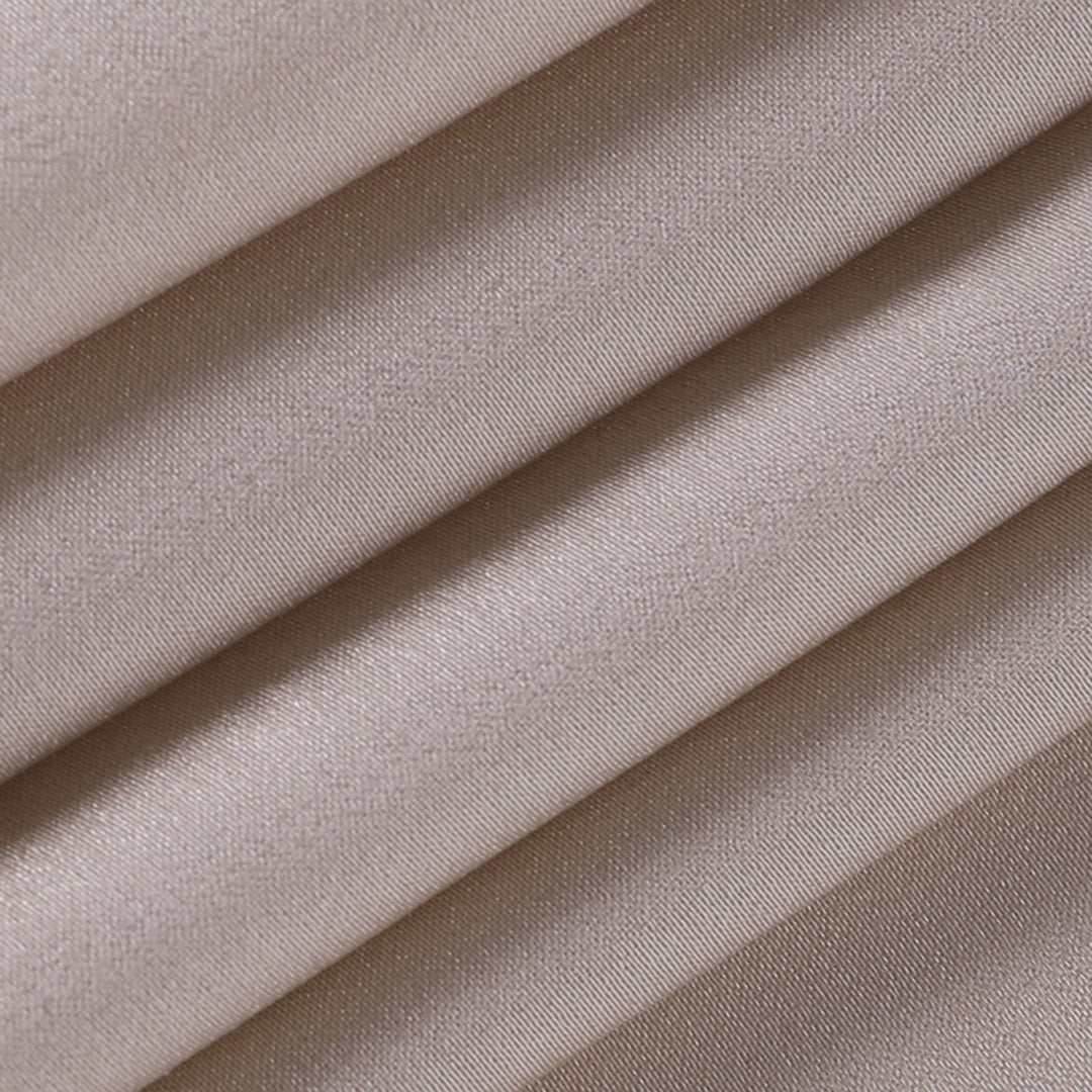 Tessuto in raso beige piegato, texture liscia e lucida, ideale per abbigliamento elegante e decorazioni. Materiale di alta qualità.