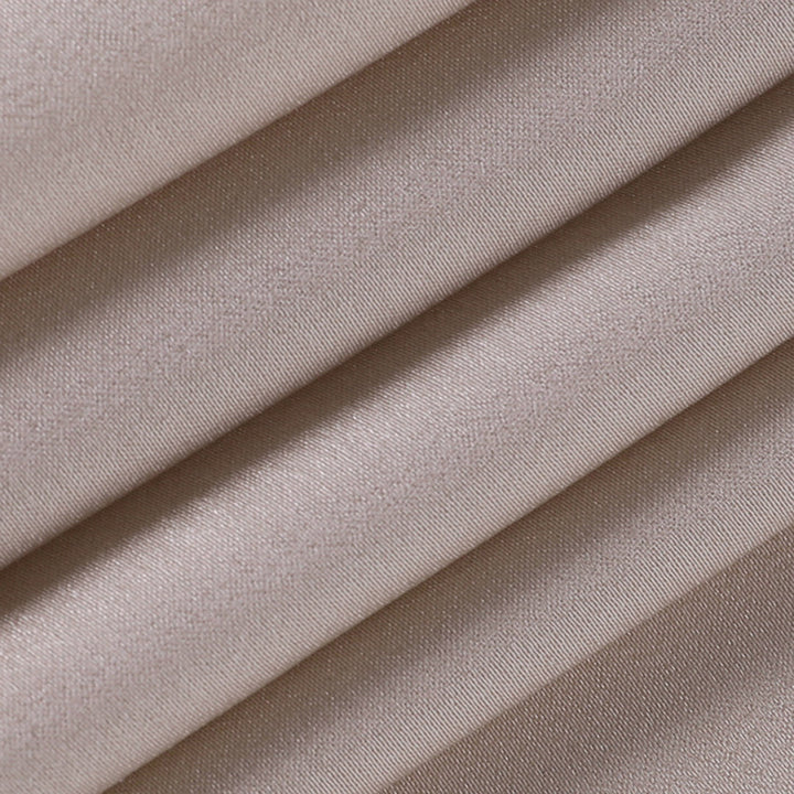 Tessuto in raso beige piegato, texture liscia e lucida, ideale per abbigliamento elegante e decorazioni. Materiale di alta qualità.