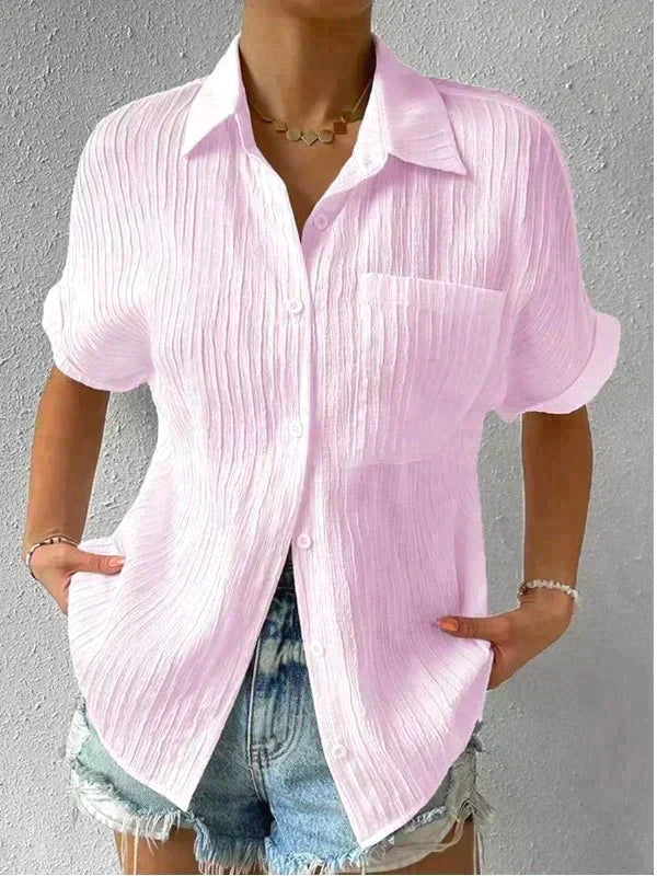 Camicia donna rosa chiaro in cotone, maniche corte, colletto classico, abbinata a shorts di jeans. Look estivo casual e fresco.