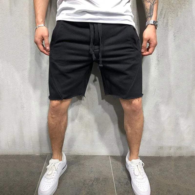 Shorts neri da uomo in cotone, stile casual, con coulisse, indossati con t-shirt bianca e sneakers bianche. Ideali per moda estiva e tempo libero.