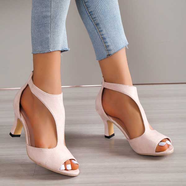 Scarpe col tacco aperte in punta color rosa chiaro, indossate con jeans. Design elegante e moderno, perfette per moda femminile e occasioni speciali.
